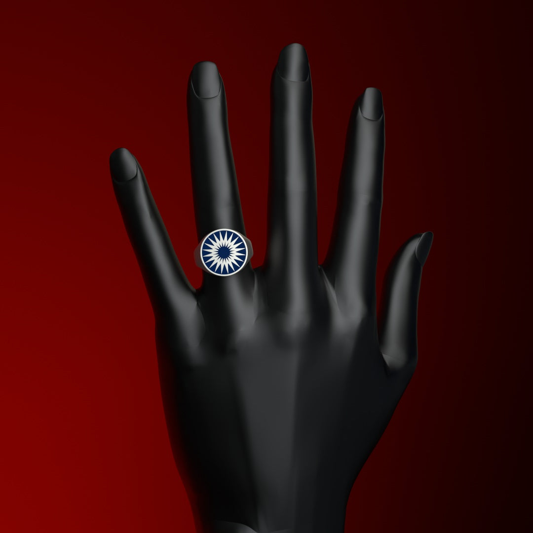 Runder Siegelring mit stilisierter Sonne in blauem Kaltemaille an Ringfinger einer Hand.