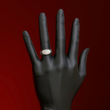 Siegelring silber mit Schmetterling Relief an Ringfinger einer Hand